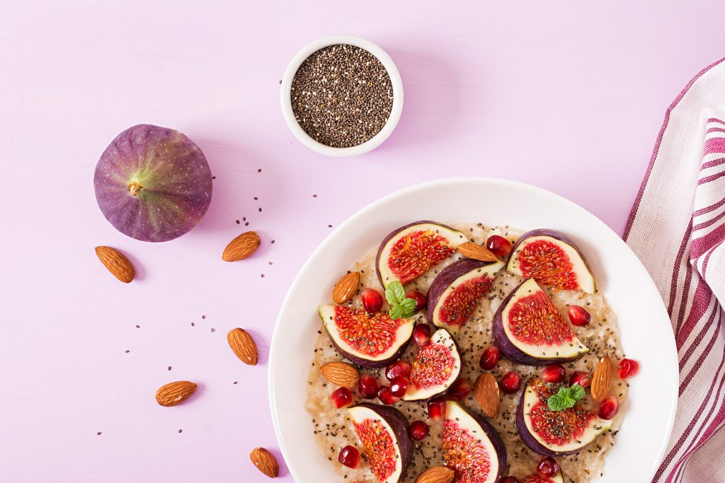 Delicious and healthy oatmeal with figs, almond and chia seeds. Healthy breakfast. Fitness food. Proper nutrition. Flat lay. Top view.