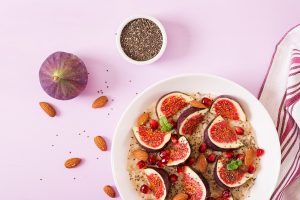 Delicious and healthy oatmeal with figs, almond and chia seeds. Healthy breakfast. Fitness food. Proper nutrition. Flat lay. Top view.