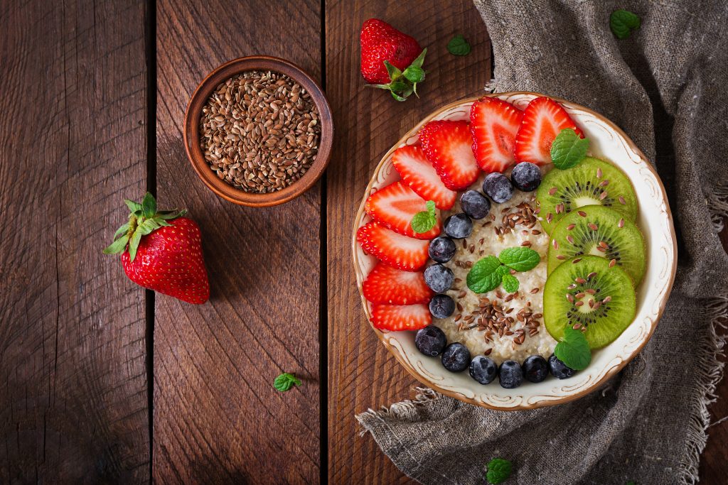 Tasty and healthy oatmeal porridge with fruit, berry and flax seeds. Healthy breakfast. Fitness food. Proper nutrition. Flat lay. Top view