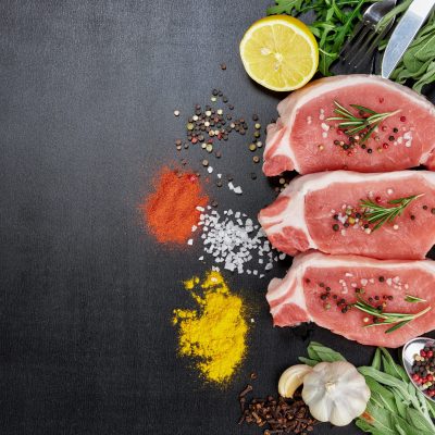 meats and vegetables on a black background